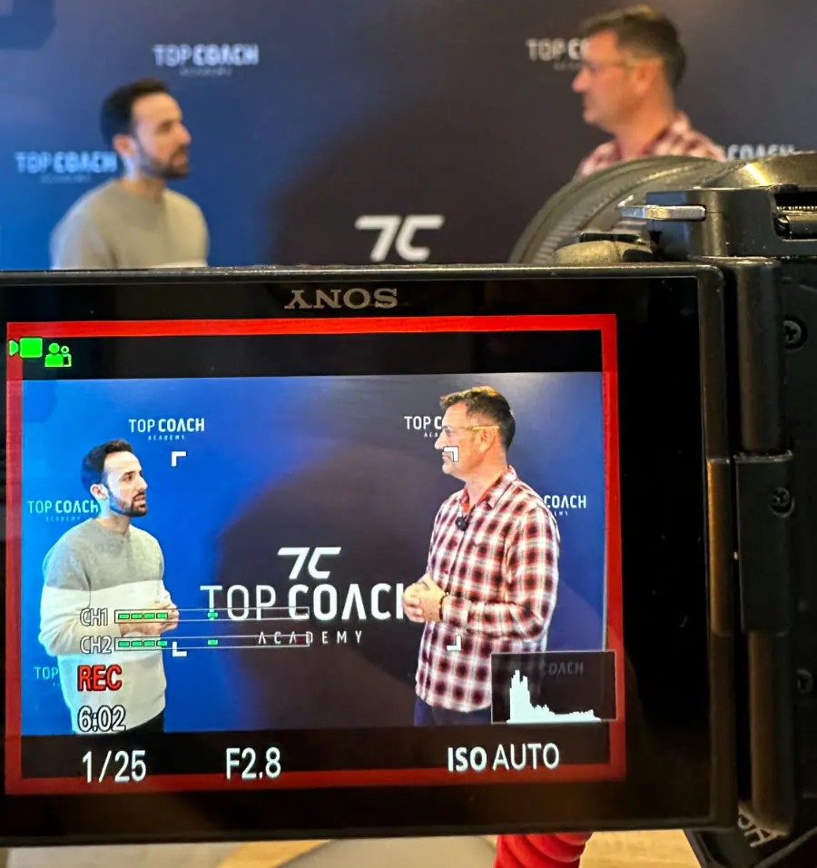 Un jeu de rôle entre deux élèves filmé devant le fond Top Coach Academy
